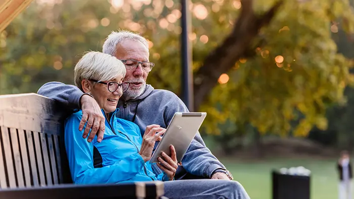 older couple outdoors on tablet