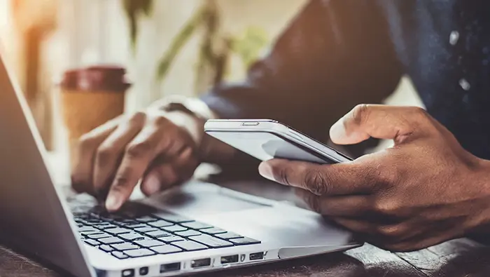 man on laptop and phone